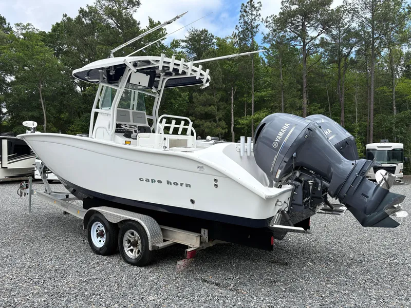 Slide: The Image of 2015 Cape Horn 27X3 boat on trailer with dual Yamaha engines, parked outdoors. - 2