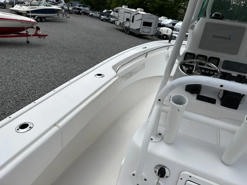 Slide: The Image of 2015 Cape Horn 27X3 boat interior with steering console, parked among other boats and RVs. - 27