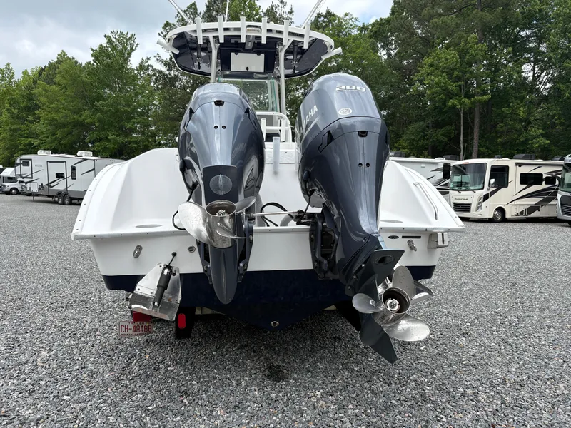 Slide: The Image of 2015 Cape Horn 27X3 boat with dual outboard motors, parked on gravel near RVs. - 3