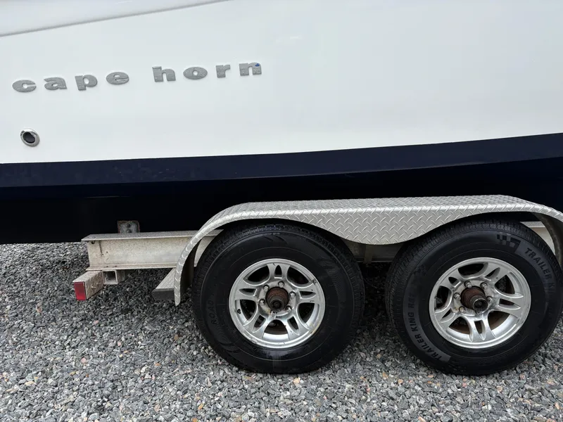 Slide: The Image of 2015 Cape Horn 27X3 boat on trailer with dual wheels on gravel surface. - 6