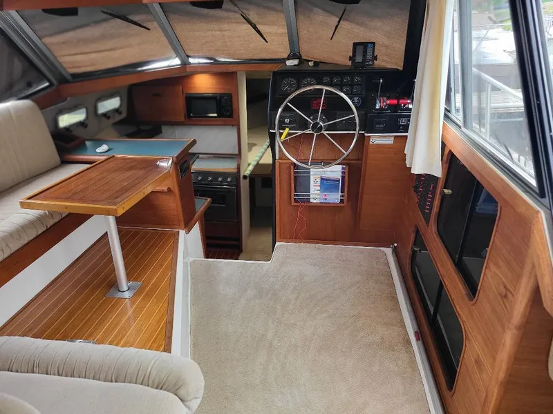Slide: The Image of 1989 Bayliner 3255 Avanti interior with helm, seating, and kitchenette. - 14