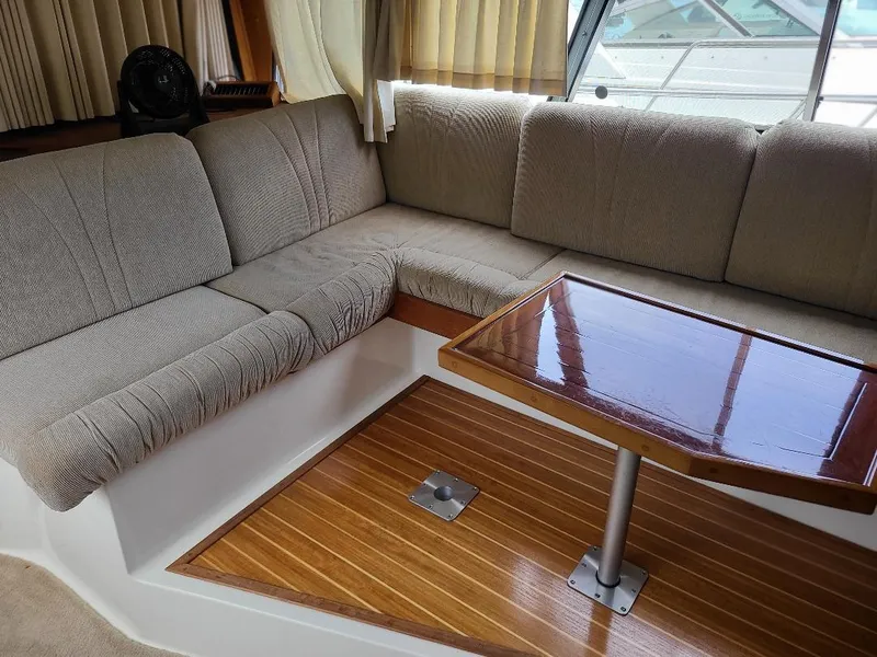Slide: The Image of 1989 Bayliner 3255 Avanti interior with cushioned seating and wooden table. - 19