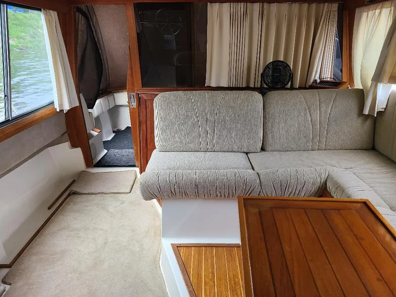 Slide: The Image of Interior of 1989 Bayliner 3255 Avanti with cozy seating and wooden accents. - 23