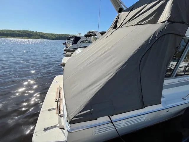 Slide: The Image of 1989 Bayliner 3255 Avanti docked, covered, on a sunny day by the water. - 4