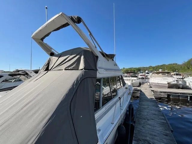 Slide: The Image of 1989 Bayliner 3255 Avanti docked at marina under clear blue sky. - 5