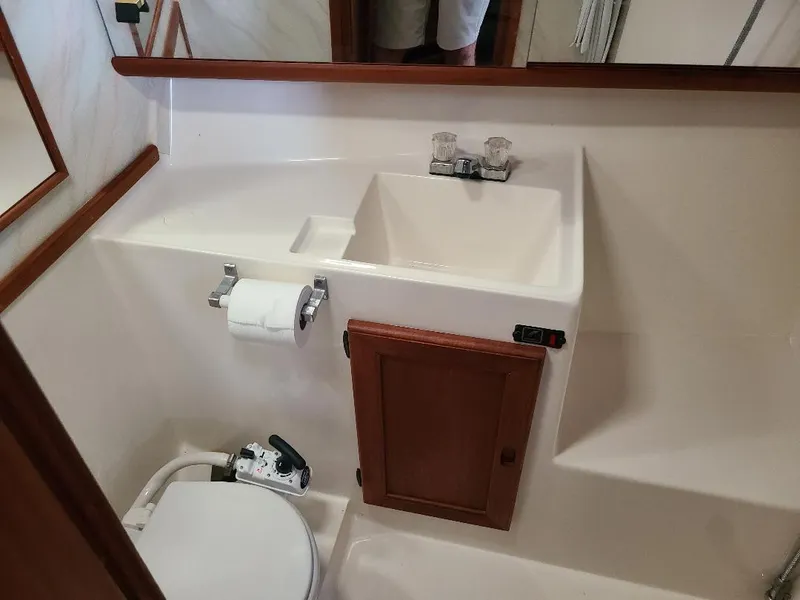 Slide: The Image of 1989 Bayliner 3255 Avanti bathroom with sink, toilet, and wooden cabinet. - 8