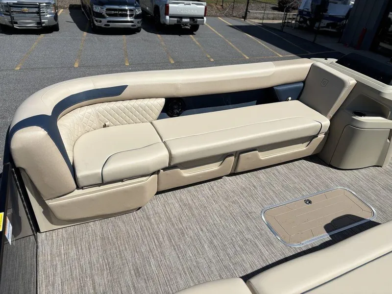 Slide: The Image of 2025 Godfrey Sweetwater 2486 SFLC boat interior with beige seating and carpeted flooring. - 13
