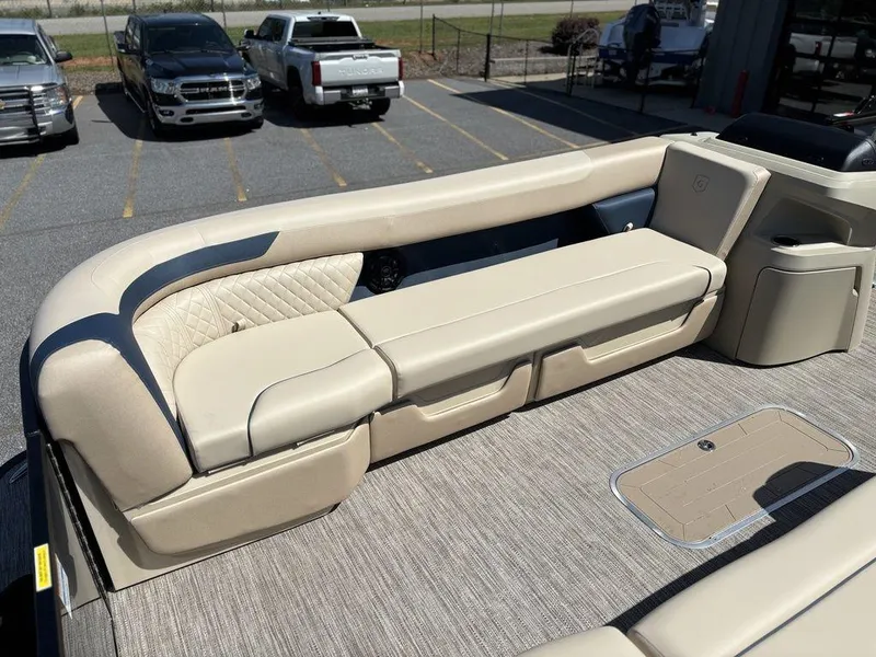 Slide: The Image of 2025 Godfrey Sweetwater 2486 SFLC boat interior with beige seating and carpeted flooring. - 15