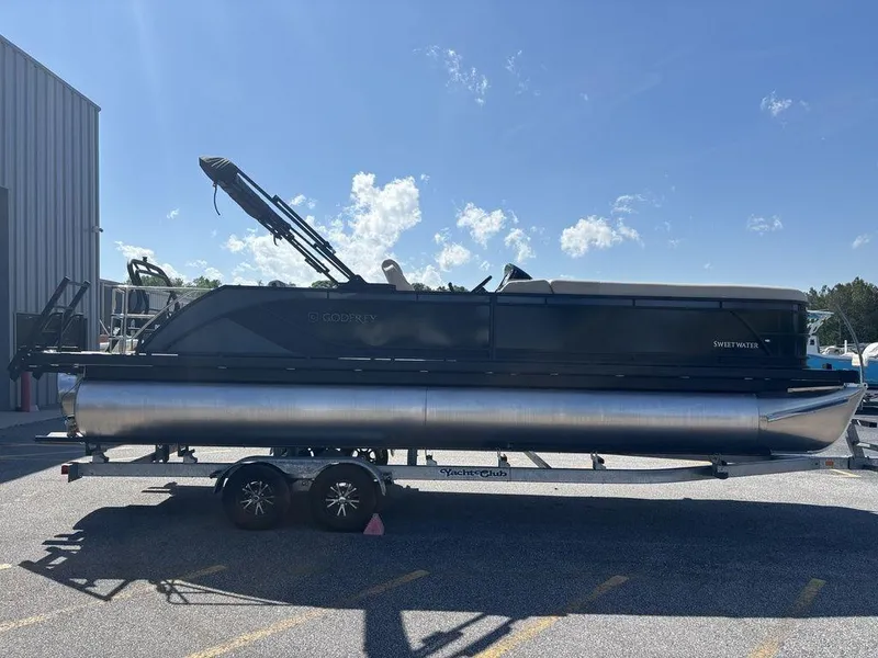 Slide: The Image of 2025 Godfrey Sweetwater 2486 SFLC pontoon boat on trailer, parked outdoors. - 17