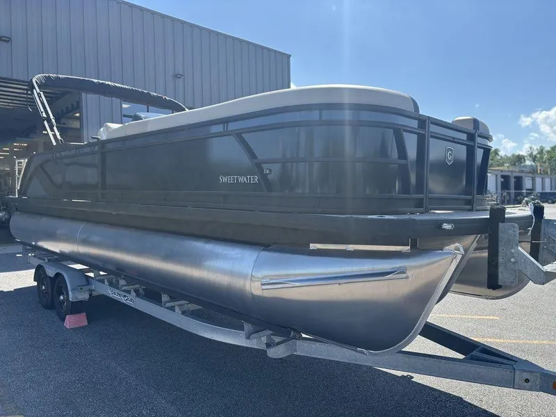 Slide: The Image of 2025 Godfrey Sweetwater 2486 SFLC pontoon boat on trailer, parked outdoors. - 18