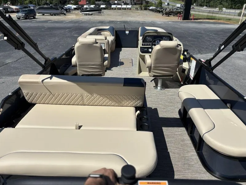 Slide: The Image of 2025 Godfrey Sweetwater 2486 SFLC pontoon boat with beige seating and modern dashboard. - 2