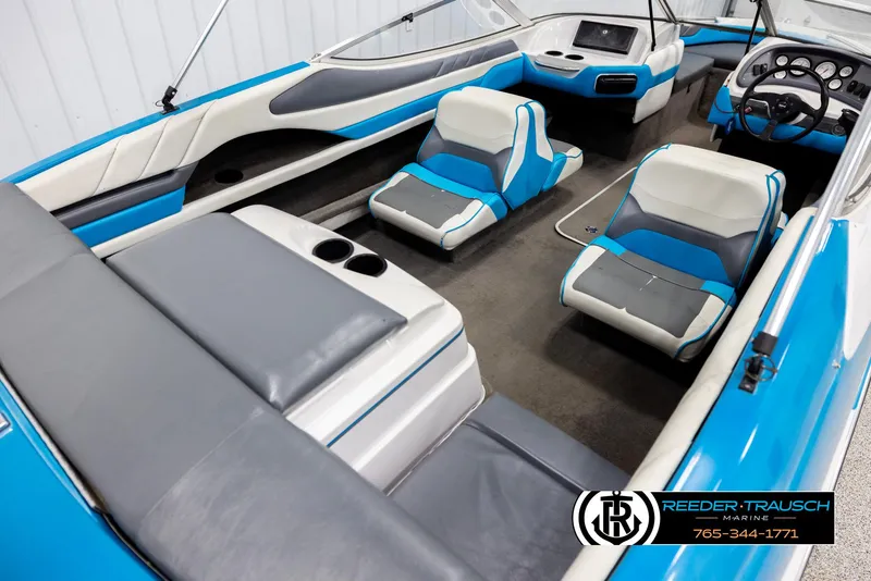 Slide: The Image of 1993 Excel 20SX boat interior with blue and white seating, dashboard, and cup holders. - 12