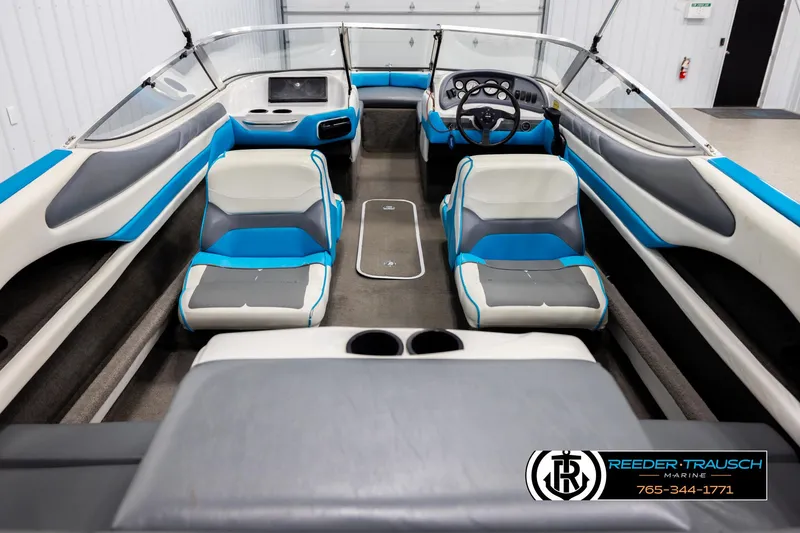 Slide: The Image of 1993 Excel 20SX boat interior with blue and gray seating, steering wheel, and dashboard. - 13