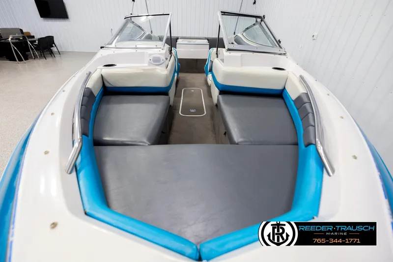 Slide: The Image of 1993 Excel 20SX boat interior with blue and gray seating, displayed in showroom. - 17