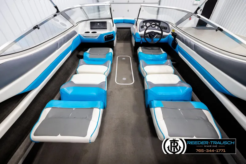 Slide: The Image of Interior of 1993 Excel 20SX boat with blue and white seating, steering wheel, and dashboard. - 22