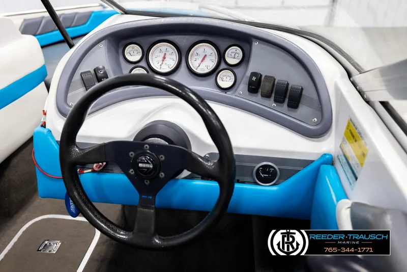 Slide: The Image of Steering wheel and dashboard of a 1993 Excel 20SX boat with gauges and controls. - 23