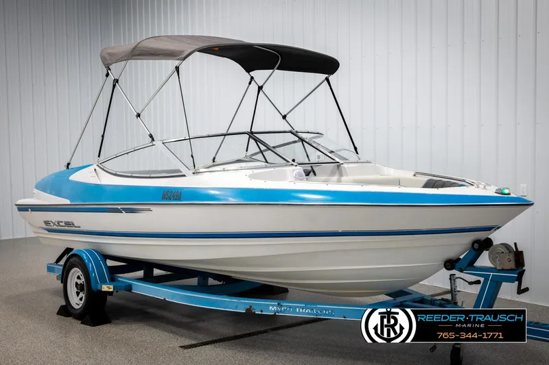 Slide: The Image of 1993 Excel 20SX boat with blue accents on a trailer in a showroom. - 3