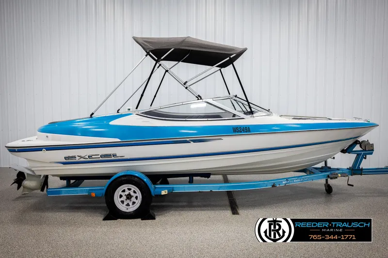 Slide: The Image of 1993 Excel 20SX boat with blue and white design on trailer, displayed indoors. - 5