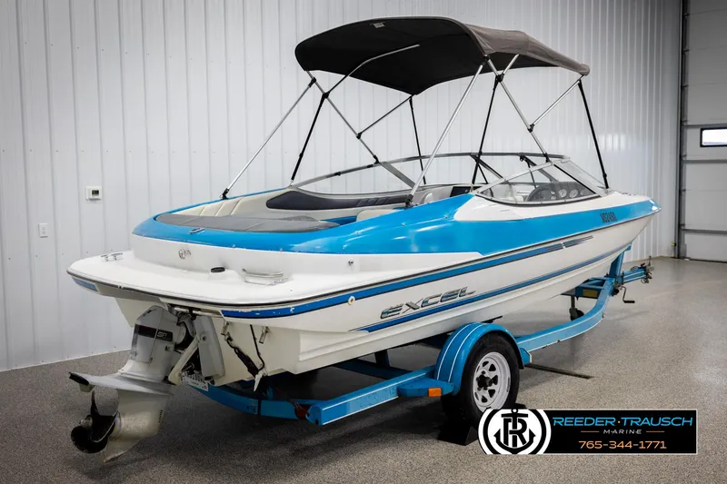 Slide: The Image of 1993 Excel 20SX boat with blue and white design on a trailer in a showroom. - 6