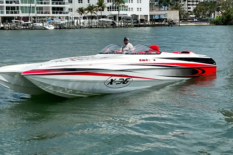 Slide: The Image of 2004 Spectre 36 Cat powerboat on water, featuring sleek design and vibrant red accents. - 0
