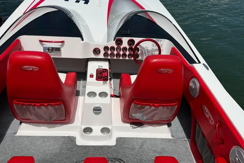 Slide: The Image of 2004 Spectre 36 Cat boat interior with red seats and dashboard controls. - 17
