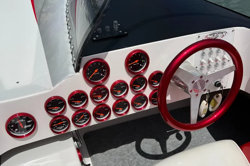 Slide: The Image of Dashboard of 2004 Spectre 36 Cat boat with red gauges and steering wheel. - 18