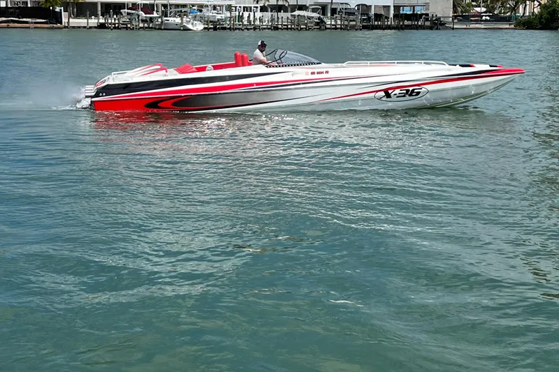 Slide: The Image of 2004 Spectre 36 Cat powerboat cruising on water, featuring sleek red and white design. - 2