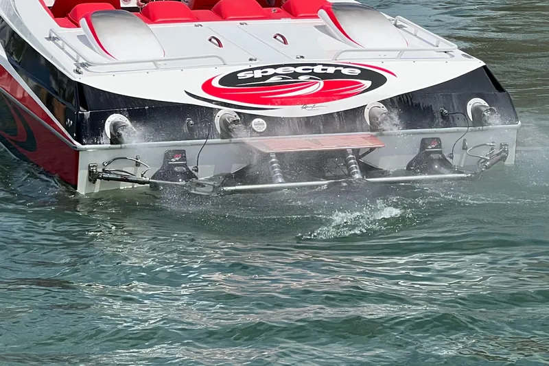 Slide: The Image of 2004 Spectre 36 Cat speedboat with red seats, cruising on water. - 7