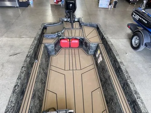 Slide: The Image of 2025 Tracker Grizzly 1650 T Prairie Wings Edition boat interior with camo design and red fuel tank. - 10