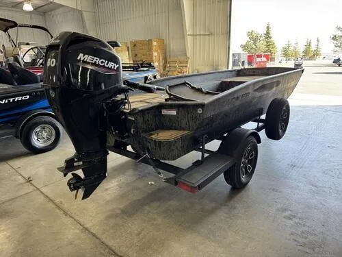 Slide: The Image of 2025 Tracker Grizzly 1650 T Prairie Wings Edition boat with Mercury engine in a garage. - 5
