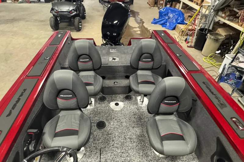 Slide: The Image of 2025 Tracker Targa V-18 WT boat interior with four gray seats in a garage setting. - 17