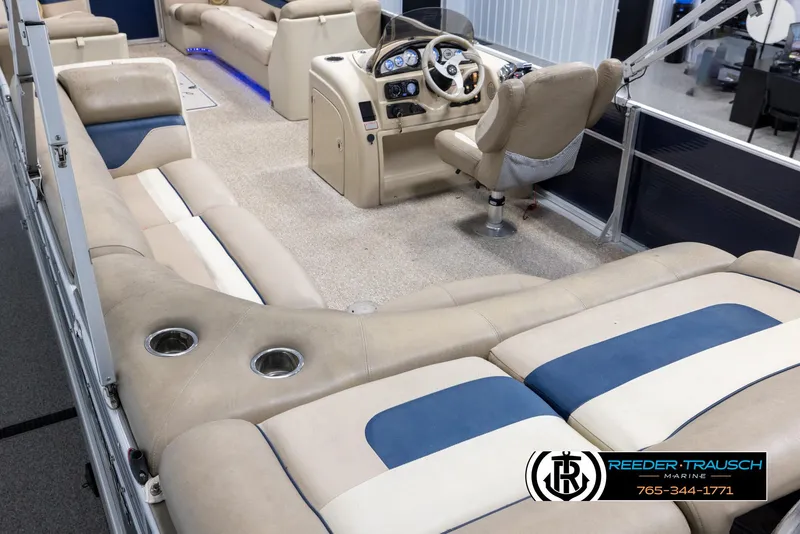 Slide: The Image of 2012 Cypress Cay 250 Cozumel boat interior with beige and blue seating, steering console, and cup holders. - 11