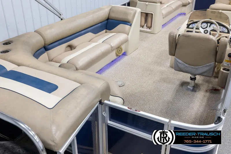 Slide: The Image of 2012 Cypress Cay 250 Cozumel pontoon boat interior with beige and blue seating. - 12