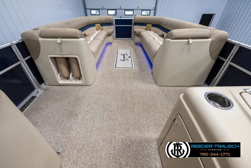 Slide: The Image of 2012 Cypress Cay 250 Cozumel pontoon boat interior with beige seating and blue LED lighting. - 18