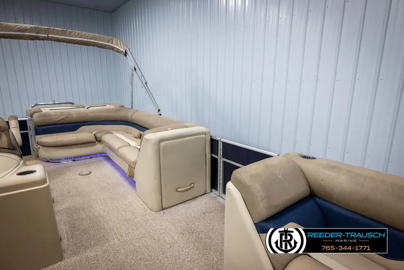 Slide: The Image of 2012 Cypress Cay 250 Cozumel pontoon boat interior with beige seating and blue accents. - 21