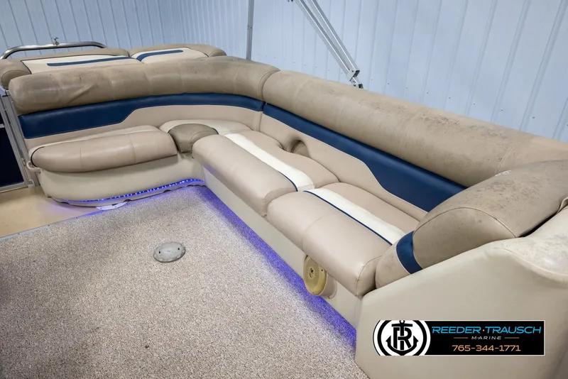 Slide: The Image of 2012 Cypress Cay 250 Cozumel boat interior with beige and blue seating, carpet, and ambient lighting. - 23
