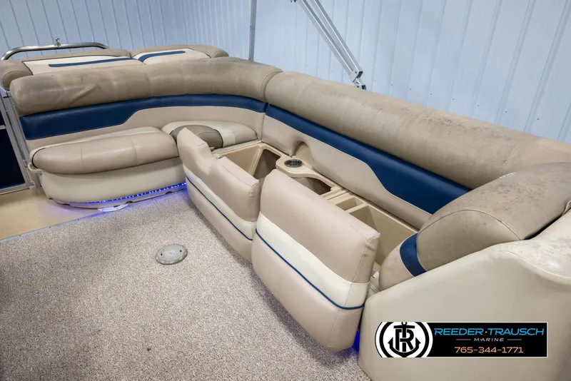 Slide: The Image of 2012 Cypress Cay 250 Cozumel boat interior with beige and blue seating, cup holders, and carpeted floor. - 24