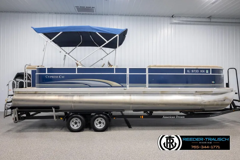 Slide: The Image of 2012 Cypress Cay 250 Cozumel pontoon boat with blue canopy on trailer in indoor showroom. - 5