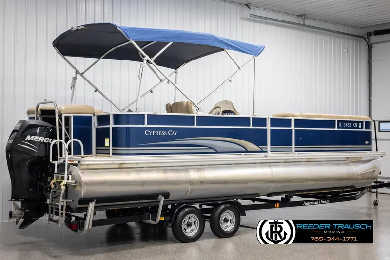 Slide: The Image of 2012 Cypress Cay 250 Cozumel pontoon boat with blue canopy on trailer in showroom. - 6