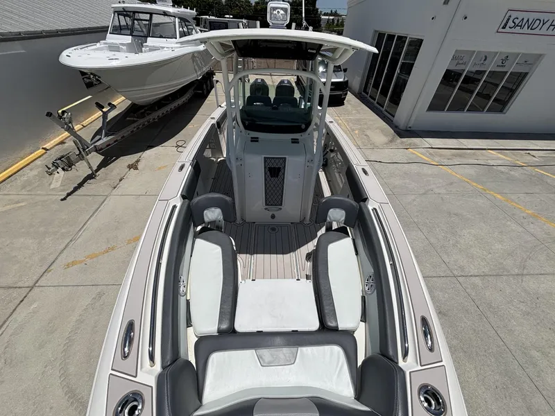 Slide: The Image of 2019 Wellcraft 262 Fisherman boat in a showroom, showcasing sleek design and spacious seating. - 10