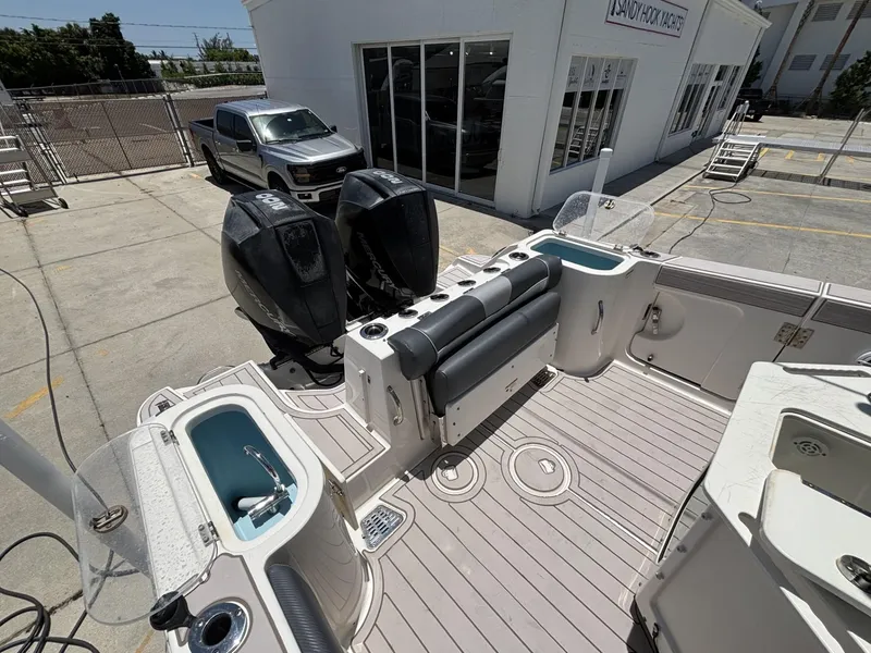 Slide: The Image of 2019 Wellcraft 262 Fisherman boat with dual engines, docked near a dealership. - 3