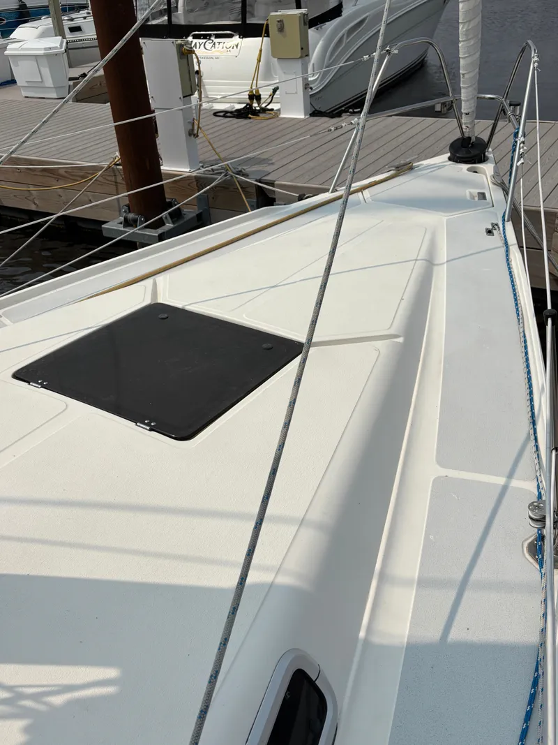 Slide: The Image of Hunter 33.5 sailboat deck, 1990 model, docked at marina with visible hatch and rigging. - 10