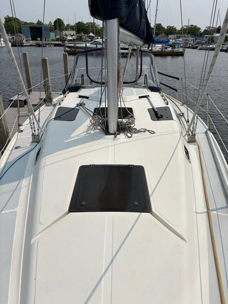 Slide: The Image of 1990 Hunter 33.5 sailboat deck view at marina, showcasing mast and rigging. - 14