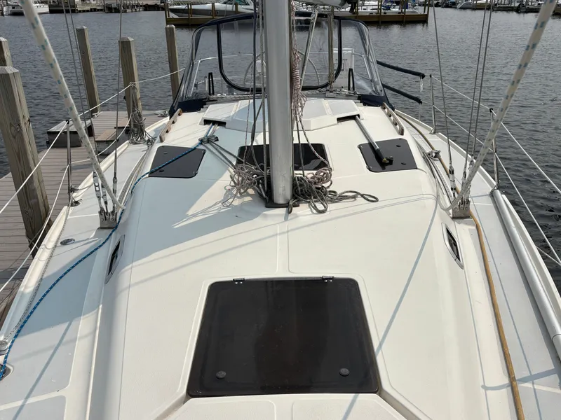 Slide: The Image of 1990 Hunter 33.5 sailboat deck with ropes and hatches at marina. - 16