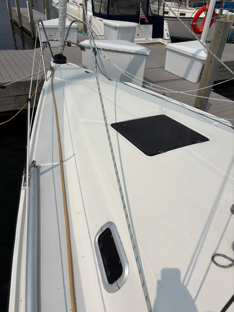 Slide: The Image of 1990 Hunter 33.5 sailboat deck at marina, showing hatch and rigging. - 17