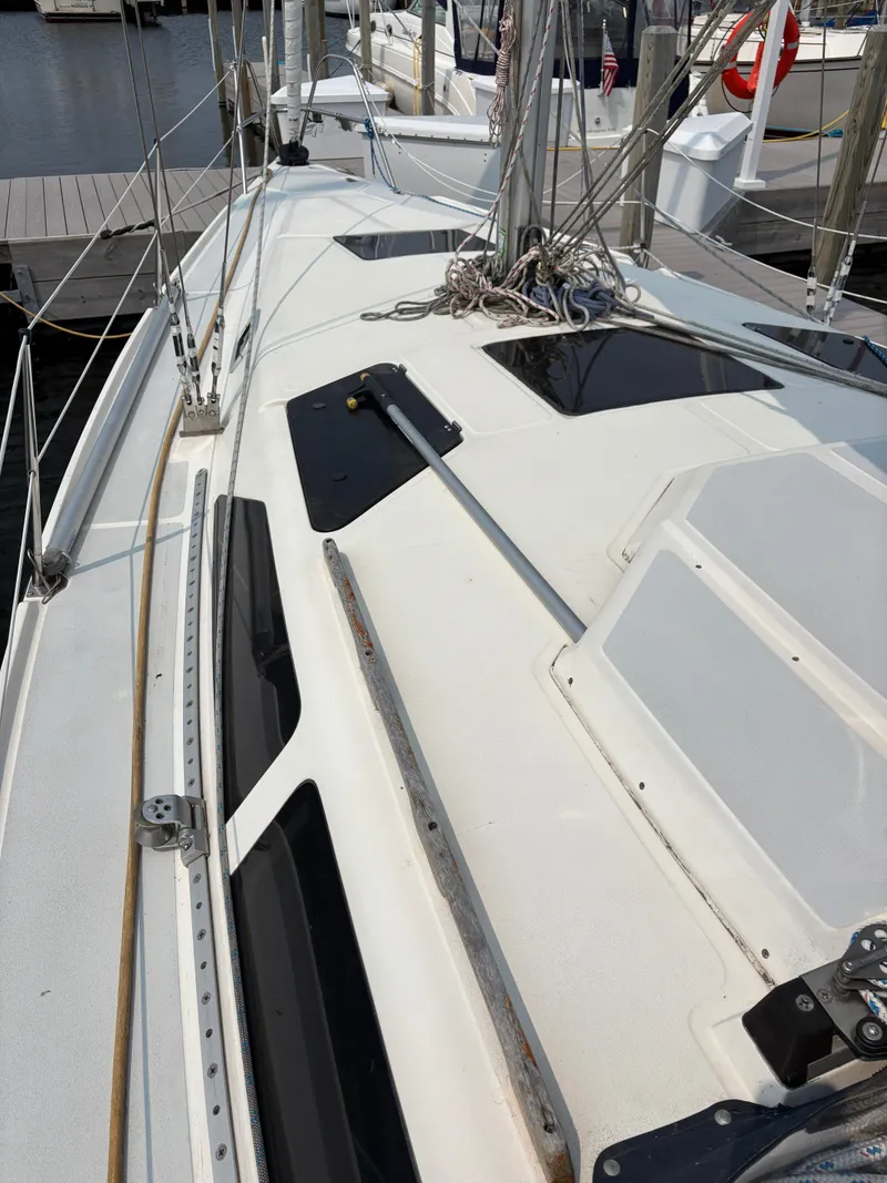 Slide: The Image of Deck view of a 1990 Hunter 33.5 sailboat docked at a marina. - 18
