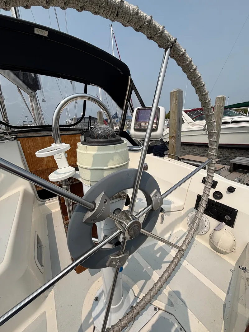 Slide: The Image of Steering wheel of a 1990 Hunter 33.5 sailboat, docked at a marina. - 22