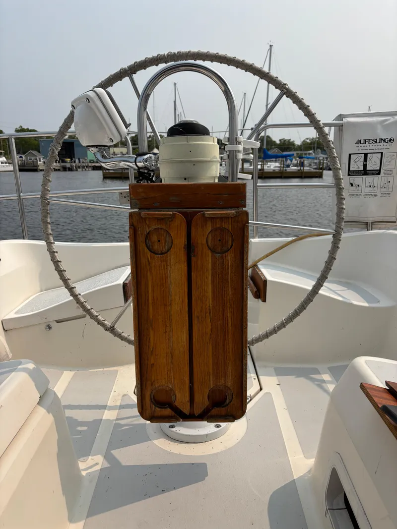 Slide: The Image of Steering wheel of a 1990 Hunter 33.5 sailboat, docked at a marina. - 27