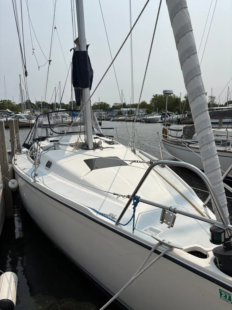 Slide: The Image of 1990 Hunter 33.5 sailboat docked at marina, featuring sleek white design and rigging. - 3