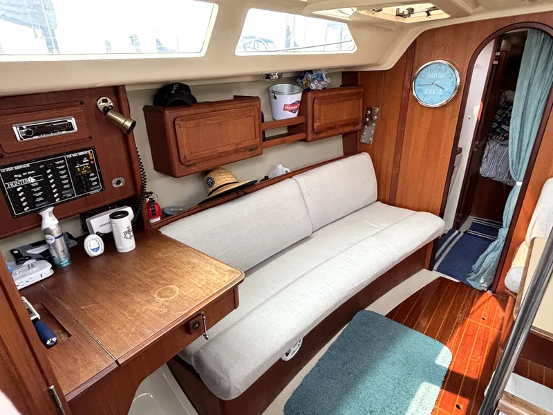 Slide: The Image of Interior of a 1990 Hunter 33.5 sailboat with cozy seating and wooden cabinetry. - 34
